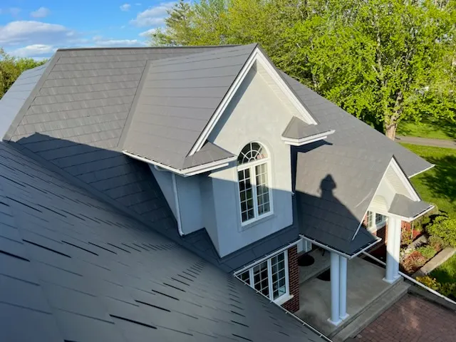 Toiture en tôle d’acier gris foncé sur une maison résidentielle au revêtement bleu