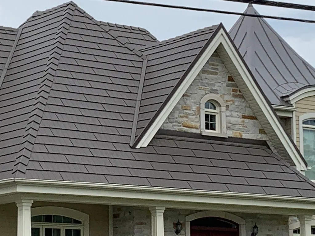 Toiture en tôle d’acier brun sur une maison à façade de pierre